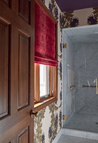 A walk-in shower in a bathroom designed by Jasmin Reese with thistle wallpaper and red window treatments, Chicago. 