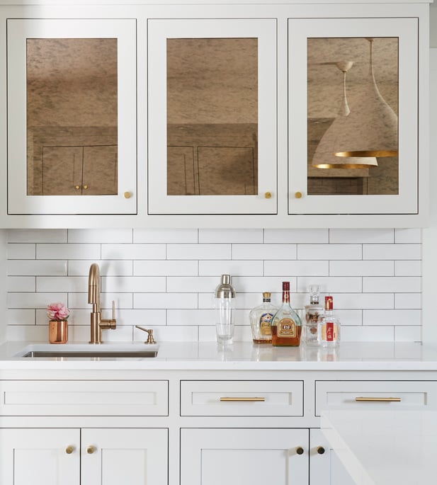 A wet bar designed by Jasmin Reese: white, mirrored copper cabinetry, white subway tile backsplash, Chicago. 