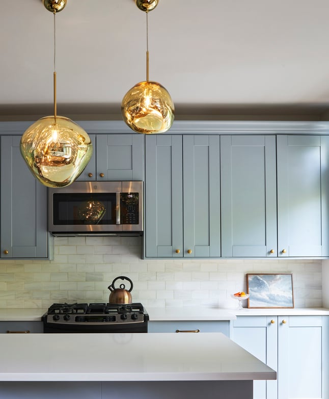 A kitchen designed by Jasmin Reese with two large organic gold globes for lighting, Chicago. 