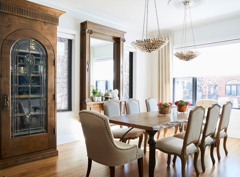 A large formal dining room design by Jasmin Reese with tan chairs and large wood cabinet, Chicago. 