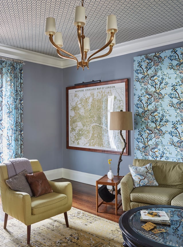 A living room with a modernist yellow leather armchair, a gold leather sofa with grey polka dots, and a large map of London and hints of robin's egg blue on the wall and on tapestry and paintings - living room design by Jasmin Reese Interiors, Chicago, USA. 