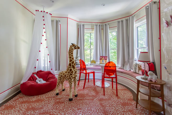A child's playroom designed by Jasmin Reese, Chicago: red acrylic chairs, window seats, red details, and red leopard carpet. 