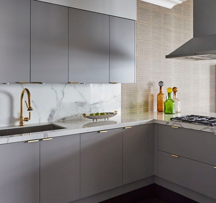 A small sleek kitchen designed by Jasmin Reese with marble and brass and gray flush cabinetry, Chicago. 