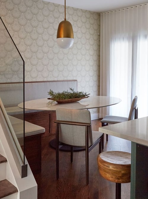 A small kitchen nook design by Jasmin Reese: booth seating, tan modernist chairs, scallop wallpaper, Chicago. 