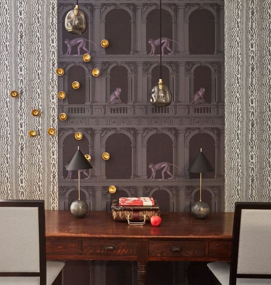 A small dining area designed by Jasmin Reese: monkeys in Roman arches wallpaper, unique lighting in gray and cream. 