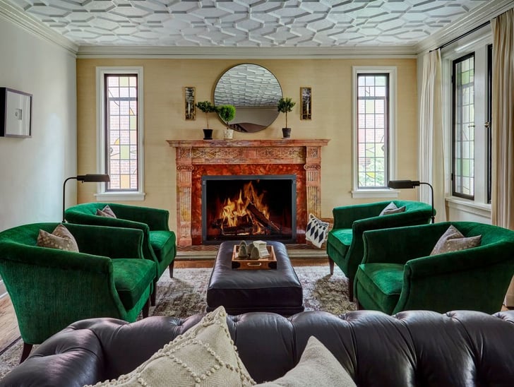 A traditional living room with four green velvet circular armchairs in front of a large fireplace painted orange - living room design by Jasmin Reese Interiors, Chicago, USA. 