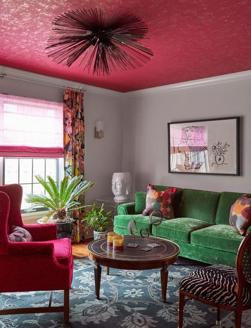 A colorful living room with a magenta ceiling and wing-back chair, a traditional green velvet sofa, and a zebra skin chair - living room design by Jasmin Reese Interiors, Chicago, USA. 