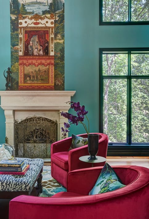Two raspberry velvet circular armchairs in a turquoise and forest green living room with a large window with trees outside - living room designed by Jasmin Reese Interiors, Chicago, USA. 