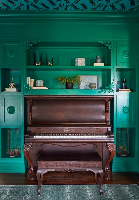 A built-in shelf detail in an emerald green living room with an antique piano - designed by Jasmin Reese Interiors, Chicago, USA. 